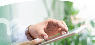 Mano de una persona usando una tablet con el dedo, en un entorno luminoso y natural