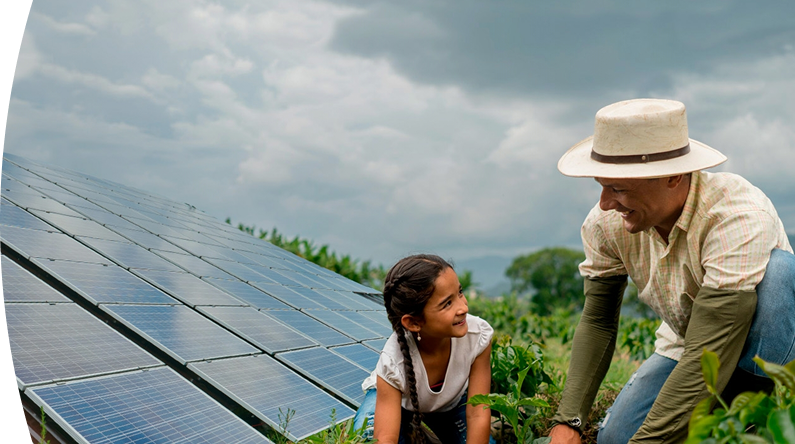 Hombre y niña trabajando juntos en un cultivo junto a paneles solares en un entorno rural