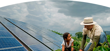 Hombre y niña trabajando juntos en un cultivo junto a paneles solares en un entorno rural