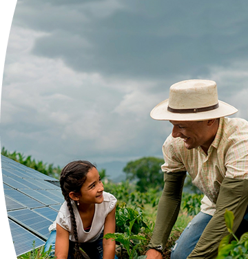 Hombre y niña trabajando juntos en un cultivo junto a paneles solares en un entorno rural
