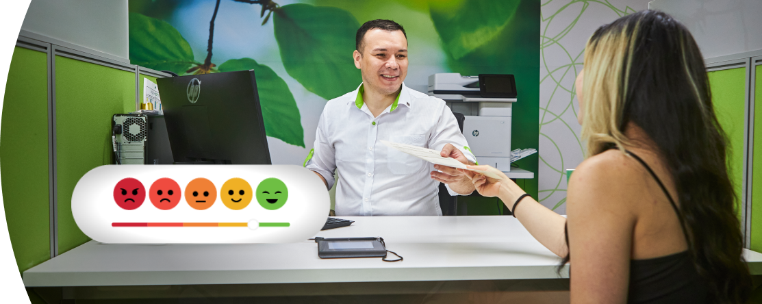 Asesor de atención al cliente de EPM entregando documentos a una usuaria en un cubículo de oficina