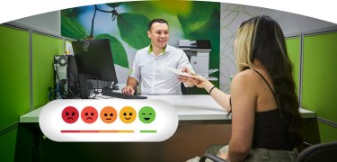 Asesor de atención al cliente de EPM entregando documentos a una usuaria en un cubículo de oficina