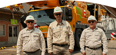 Fotografía de tres trabajadores de EPM con casco y uniforme posan frente a un camión grúa de mantenimiento