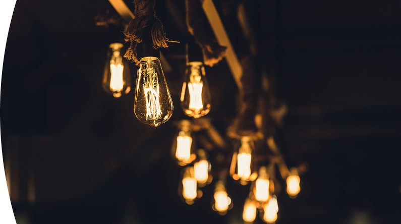 Bombillos colgantes con luz cálida encendidos en un ambiente interior oscuro, creando una iluminación decorativa y acogedora