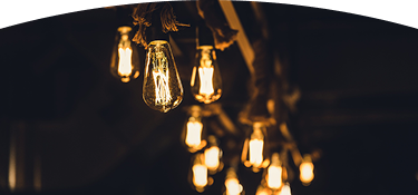 Bombillos colgantes con luz cálida encendidos en un ambiente interior oscuro, creando una iluminación decorativa y acogedora