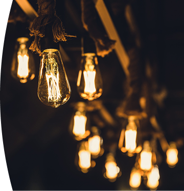 Bombillos colgantes con luz cálida encendidos en un ambiente interior oscuro, creando una iluminación decorativa y acogedora