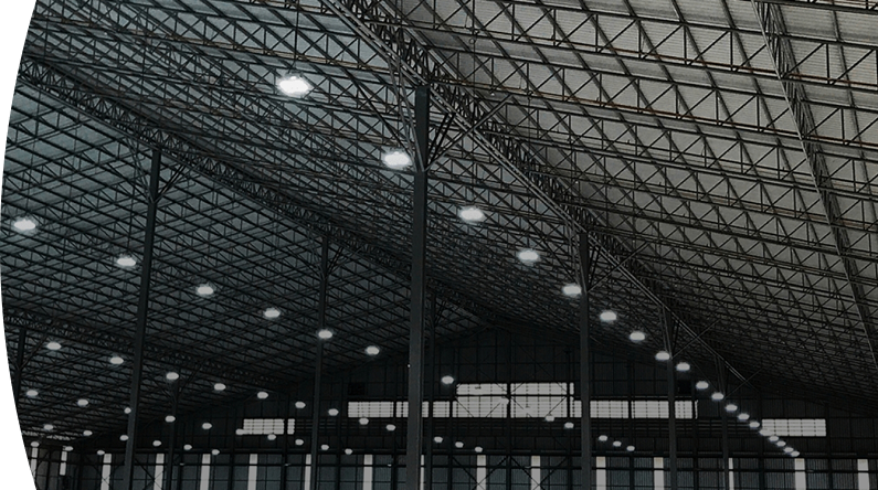 Vista de una bodega industrial moderna con estructura metálica y techo de gran altura iluminado con luces led