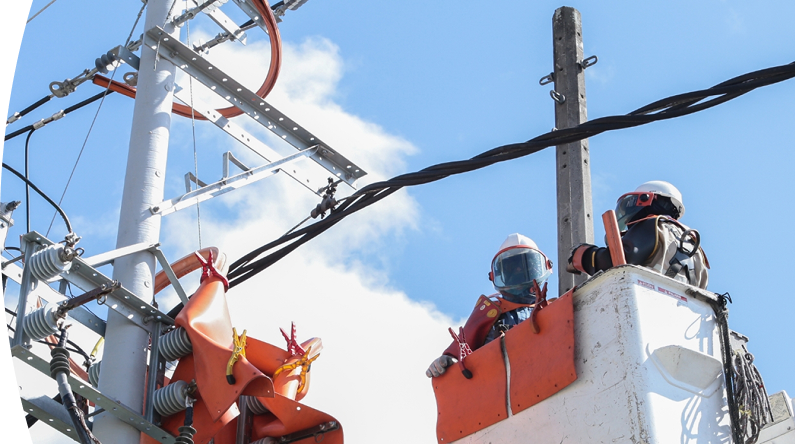  trabajador en una grúa elevadora reparando cables de electricidad