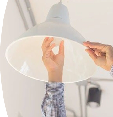 persona ajustando una lámpara de techo con ambas manos