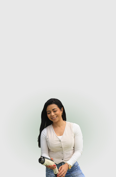 Mujer sonriente sostiene con sus manos un conector de carga