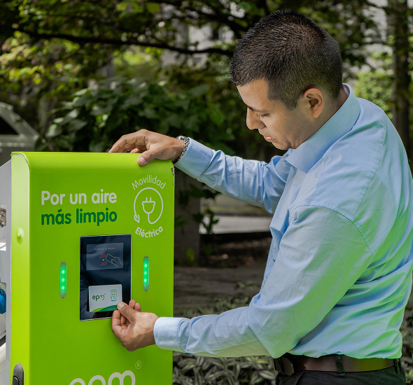 Hombre utilizando una estación de carga eléctrica