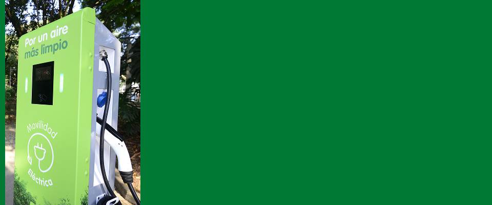 Un usuario conectando un auto eléctrico a estación de carga en fondo claro