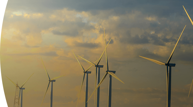 Banner ''Energías renovables'' parque eólico con varios aerogeneradores produciendo energía renovable al atardecer bajo un cielo nublado