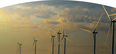 Banner ''Energías renovables'' parque eólico con varios aerogeneradores produciendo energía renovable al atardecer bajo un cielo nublado