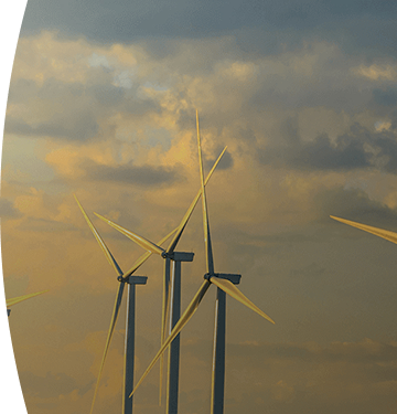 Banner ''Energías renovables'' parque eólico con varios aerogeneradores produciendo energía renovable al atardecer bajo un cielo nublado