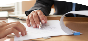 Mano de una persona señalando y revisando un documento durante un proceso de firma o validación