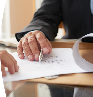 Mano de una persona señalando y revisando un documento durante un proceso de firma o validación