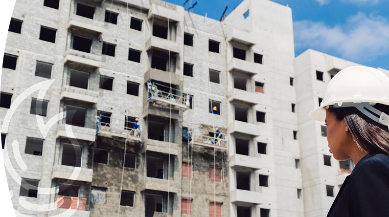 Mujer con un casco blanco viendo un edificio en construcción