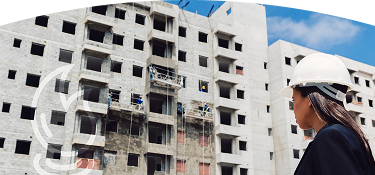 Mujer con un casco blanco viendo un edificio en construcción