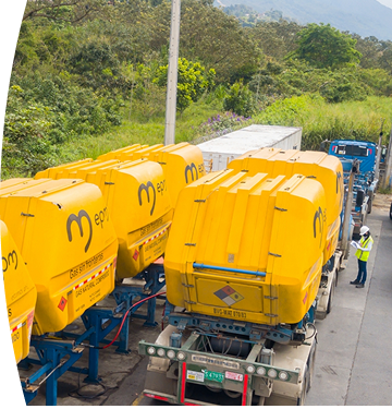 Tractocamiones con grandes contenedores amarillos marcados con el logo de EPM, alineados en una estación de carga