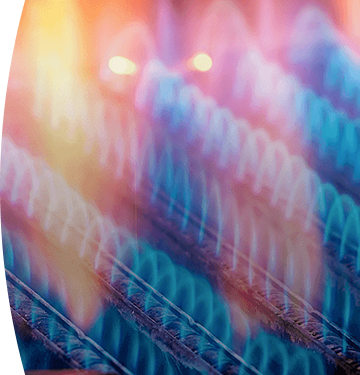 Quemadores industriales encendidos con llamas azules y naranjas