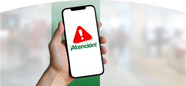 Mano sosteniendo un celular con señal de alerta roja y mensaje “¡Atención!”