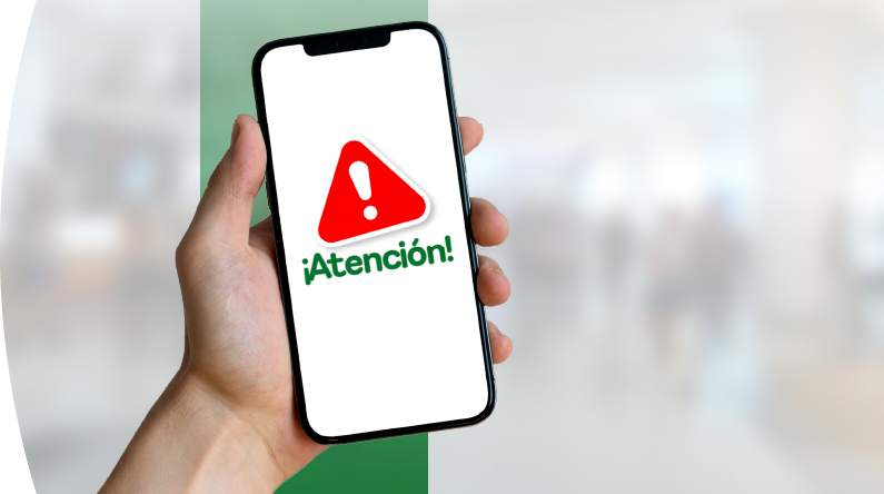 Mano sosteniendo un celular con señal de alerta roja y mensaje “¡Atención!”