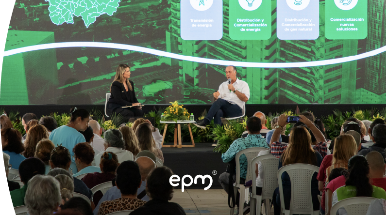 Evento de rendición pública de cuentas de EPM con panelista acompañada del gerente general de EPM John Maya Salazar, en escenario frente a la audiencia y el mensaje  de "Rendición pública de cuentas gestión 2025".