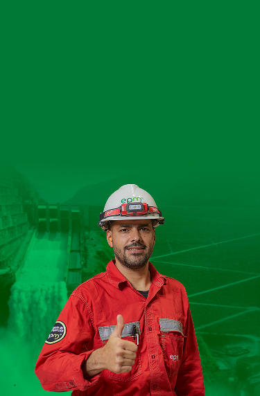 Trabajador de EPM con casco y uniforme rojo hace señal de aprobación sobre fondo verde.