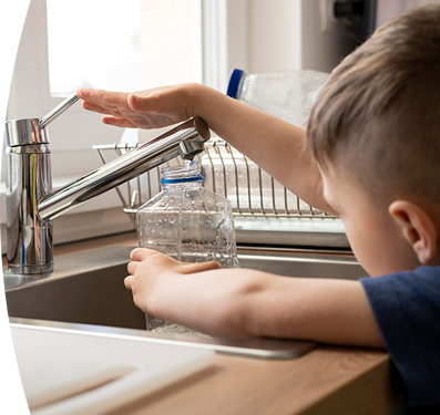 Imagen de un niño llenando una botella con agua
