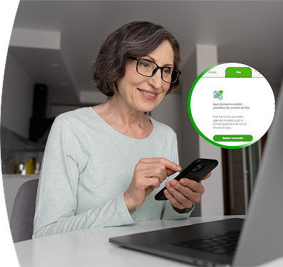 Mujer mayor con gafas, usando su celular frente al portátil, gestionando un servicio de EPM.