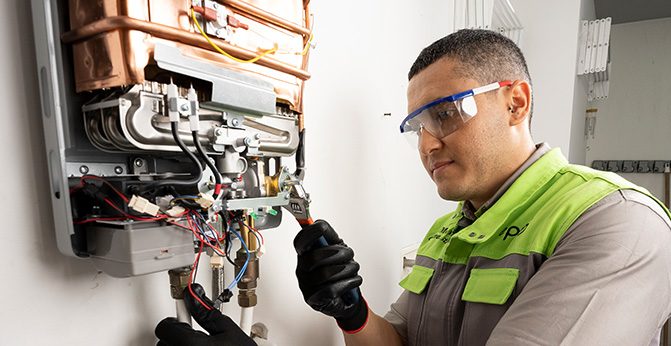 Técnico con gafas protectoras realiza instalación de un calentador