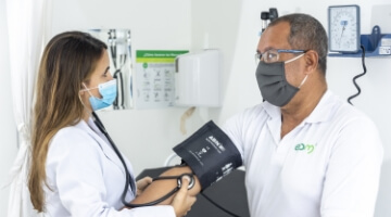 Infórmate sobre la "Unidad de Servicio Médico". El acceso a esta información tiene una imagen de un médico con bata blanca y mascarilla midiendo la presión arterial de una paciente. 