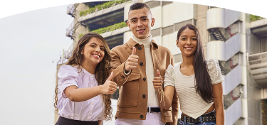 Tres jóvenes sonrientes, un hombre y dos mujeres, miran a la cámara y levantan los pulgares en señal de aprobación frente a un edificio inteligente de EPM