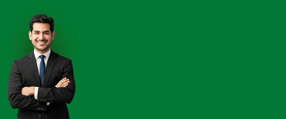 Hombre con camisa lila sonriendo hace gesto de corazón con las manos, sobre fondo claro