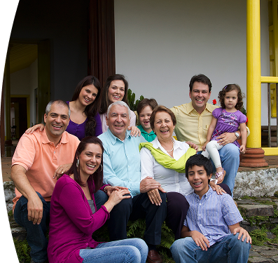 Familia multigeneracional reunida en la entrada de una casa, sonriendo y compartiendo un momento feliz