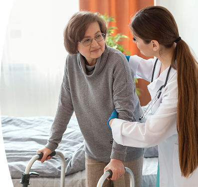 Doctora apoya a una mujer mayor que usa caminador, sosteniéndola del brazo