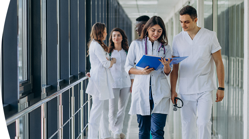 Dos doctores caminando mientras revisan una historia médica