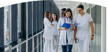 Dos doctores caminando mientras revisan una historia médica