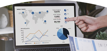 Computador mostrando gráficas de informes financieros y una mano señalando la pantalla