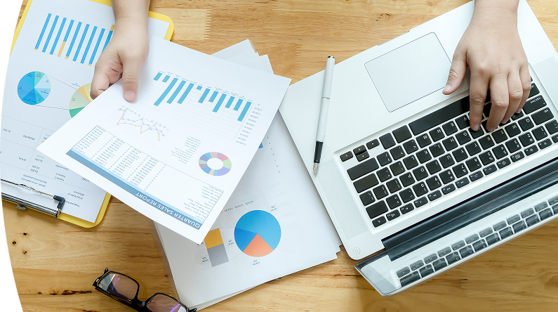 Manos de una persona en un escritorio lleno de papeles