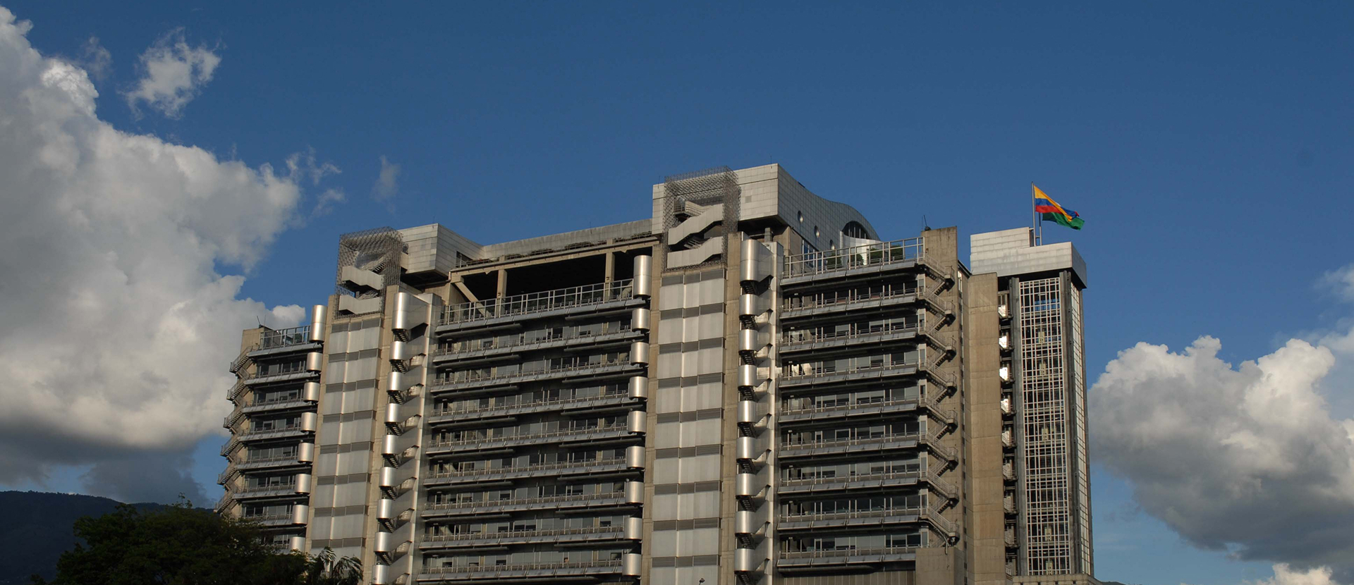 Información corporativa. Imagen de edificio de EPM con bandera ondeando en la parte superior, cielo azul con algunas nubes.