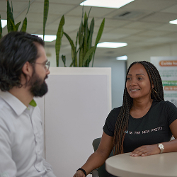 Dos personas conversan en una oficina, sentadas frente a frente