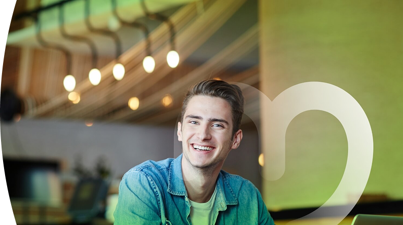 Joven sonriente con camisa de mezclilla en oficina moderna iluminada