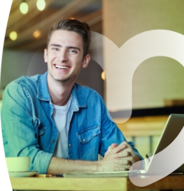 Joven sonriente con camisa de mezclilla en oficina moderna iluminada