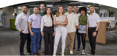 Grupo de personas posando y sonriendo en un ambiente empresarial