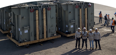 grupo de trabajadores al lado de generadores eléctricos 