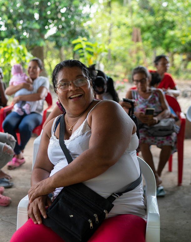 Mujer sonriente en una reunión comunitaria de EPM, representando la gestión social del proyecto Hidroituango.
