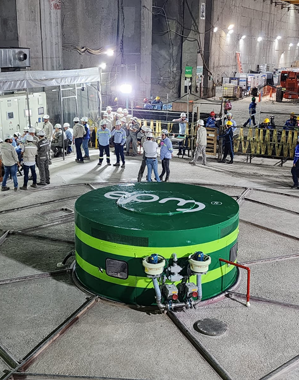 Personal técnico trabajando alrededor de una unidad de generación de energía con el logo de EPM en Hidroituango.