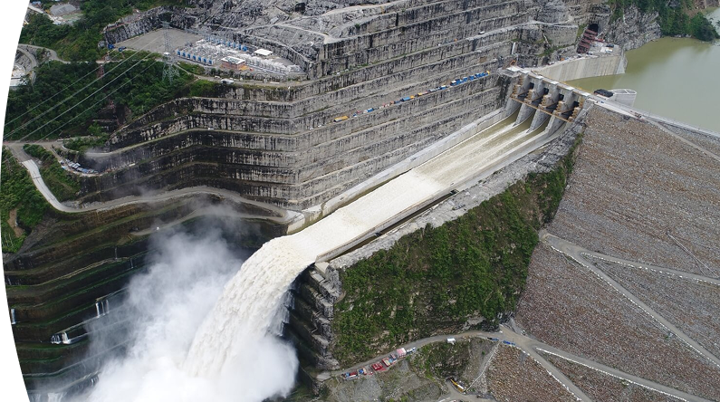 Banner ''Central Hidroituango'' vista aérea de la represa Hidroituango en Antioquia, Colombia, mostrando el vertedero abierto y la fuerza del agua liberada, junto a la infraestructura hidroeléctrica y las montañas circundantes